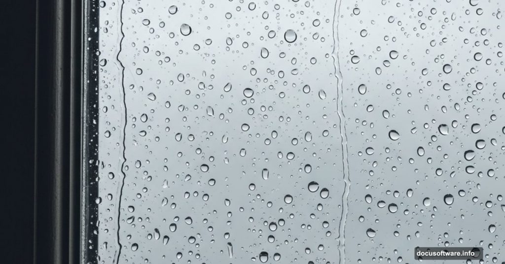 Realistic rainy window with water droplets and Adobe Photoshop logo